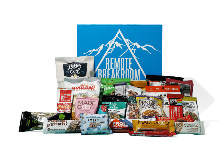 Remote Breakroom Snack Box with a variety of snacks in front of the box. Snacks include Lesser Evil Popcorn, Made Good Granola Bites, Wonderful Pistachios, Think Jerky, Good Should Taste Good Tortilla Chips, and other healthy snack options.